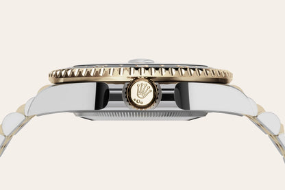 Close-up of a Rolex watch with a gold and silver band on a white background- Hublot